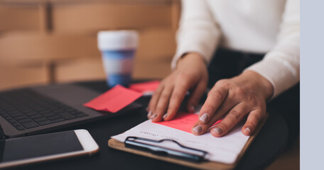 Anonymous woman attaching sticker on clipboard