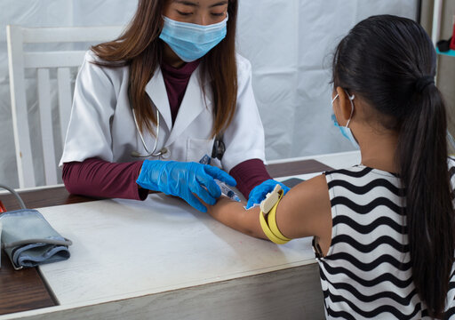 Doctor taking blood sample from a child's arm