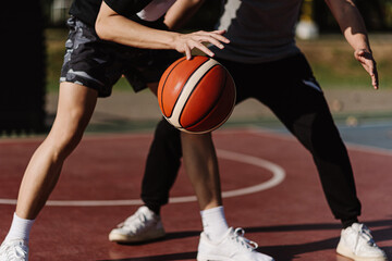 Fototapeta premium Sports and recreation concept two male basketball players enjoying playing basketball together on the sports ground