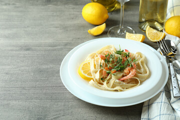 Concept of tasty eating with shrimp pasta on gray textured table