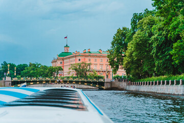 A boat trip on the Neva River and a view of the embankment in the city center at sunset. Saint Petersburg, Russia - 28 June 2021