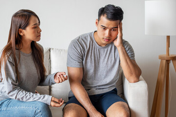 Unhappy young man have problems being quarrel with his wife sitting on sofa together at living...