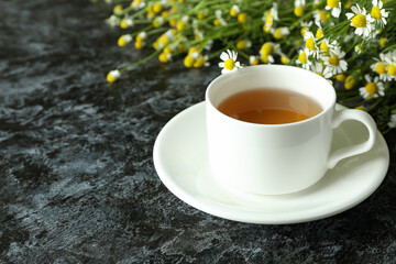 Cup of chamomile tea on black smokey table