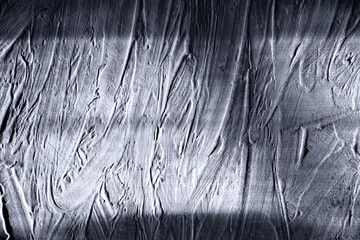 Gray abstract texture of surface covered with putty with hard shadow. Grain and noise effect.  Wall...