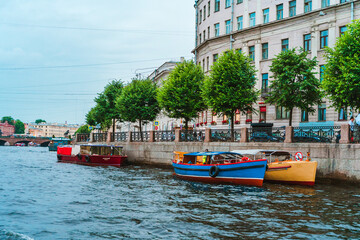 Beautiful view of the Neva river canal in the city center with tourist excursion boats, postcard view. Saint Petersburg, Russia - 28 June 2021
