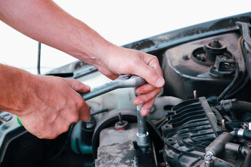Car repair. Auto mechanic working on car engine in mechanics garage. Repair service. close-up shot