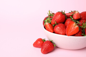 Bowl of fresh strawberry on pink background
