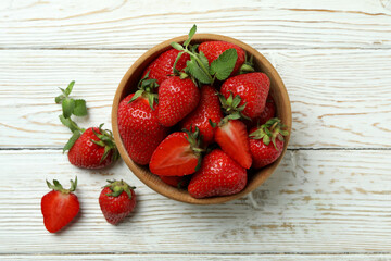 Bowl of strawberry on white wooden background