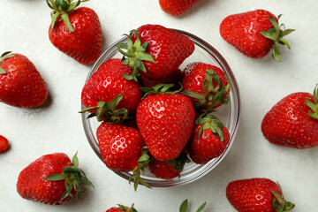 Bowl of fresh strawberry on white textured background