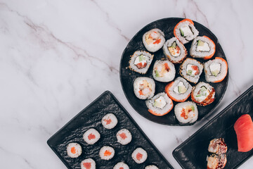 Sushi bar lunch menu - different sushi rolls with salmon, avocado and smocked eel on white marble table background with copy space - futomaki. uramaki, maki. Order food online, delivery food concept