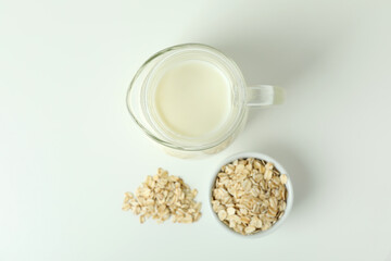 Pitcher of milk and cereals on white background