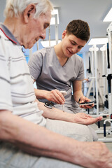 Obraz premium Pleasant physician evaluating muscle health condition of elderly man