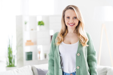 Naklejka premium Portrait of attractive cheerful wavy-haired girl wearing cozy clothes staying at home light white house flat room indoors