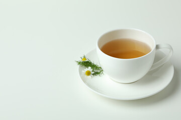 Cup of chamomile tea on white background