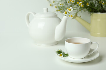Concept of breakfast with chamomile tea on white table