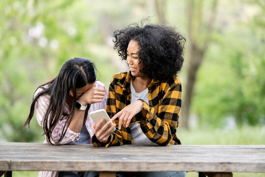 Multiethnic couple of lesbian women gossiping together