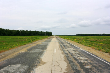 Empty asphalt road in green field