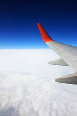 Airplane wing in the blue sky