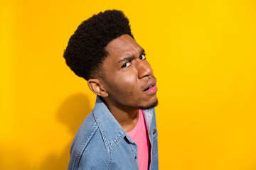 Photo of suspicious young dark skin man look disbelief eye empty space isolated on shine yellow...