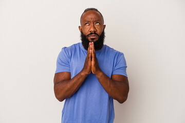 African american man with beard isolated on pink background holding hands in pray near mouth, feels confident.