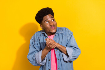 Photo of young funky afro american man look empty space plan think idea isolated on yellow color...
