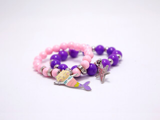 Bracelets for girls. Mermaid cat and star charm bracelets for girls. Pink and violet bangles. Accessories. Ornaments. Jewels. Clothing accessories. Fashion accessories. Isolated white.