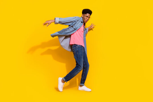 Full body photo of happy cheerful dark skin man fly wind shirt dancer isolated on bright yellow color background