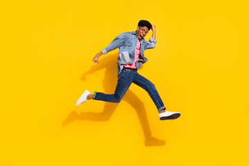 Fototapeta na wymiar Full body photo of crazy afro american young man jump up run empty space winner isolated on yellow color background