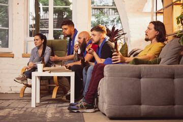 Company of friends, men and woman watching TV, sport match together. Concept of friendship, leisure...
