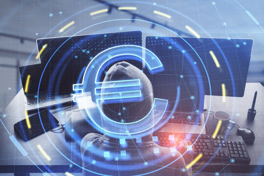 Top view of hacker using computer with glowing euro sign in blurry office interior. Online banking and theft concept. Double exposure.