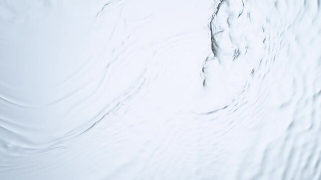 Super slow motion of water surface on white background. Filmed on high speed cinema camera, 1000 fps.