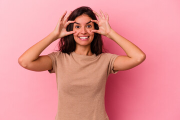 Young caucasian woman isolated on pink background keeping eyes opened to find a success opportunity.