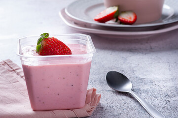 .Delicious strawberry mousse in a plastic cup for delivery with fresh strawberries. Copy space