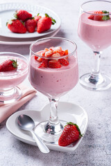 Delicious strawberry mousse in glass bowl with fresh strawberries.
