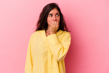 Young caucasian woman isolated on pink background biting fingernails, nervous and very anxious.