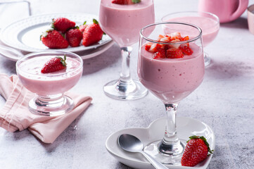 Delicious strawberry mousse in glass bowl with fresh strawberries.