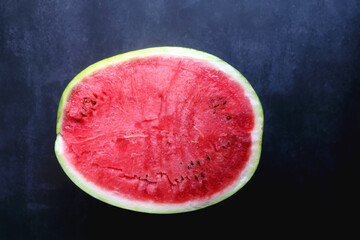 Half of watermelon on dark background. Top view.