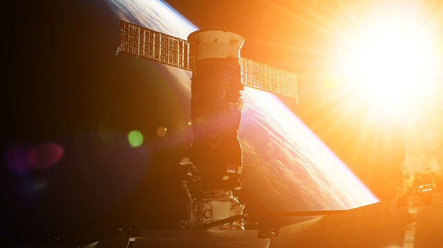 View on ISS Progress resupply ship, View out from a passenger window on the SpaceX Crew Dragon. Docking maneuver near the Space Station. Elements of image furnished by NASA