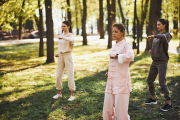 Three women pressing left fist to their chest