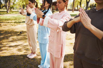 People finishing tai chi activity with hold fist salute