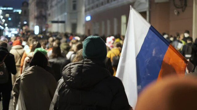 Non violent strike with Russian banner flag. Crowded streets filled with oppositional people during anti government public capital riot rally. Protesters use state banners and flags in Russia.