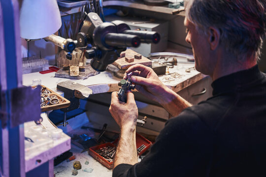 Caucasian Male Cutting Pink Gem With Faceting Instrument