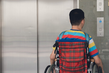 Asian disabled teen boy on wheelchair determining to use the elevator by himself, Lifestyle in the...