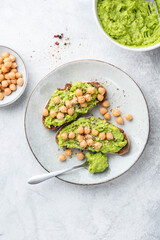 Toast with avocado and chickpeas on a plate. Healthy vegan vegetarian snack toast