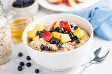 Healthy vegetarian breakfast food oatmeal porridge with fruits and honey. Weight loss, clean eating lifestyle concept