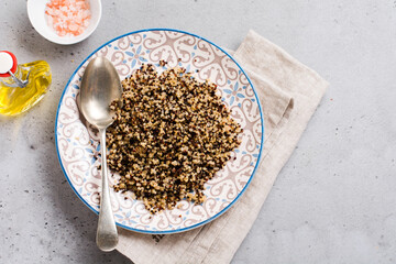 Cooked white, red and black quinoa in white plate on grey rustic background, top view, place for text recipes or menu. Vegan Superfood, healthy eating and nutrition or diet concept.