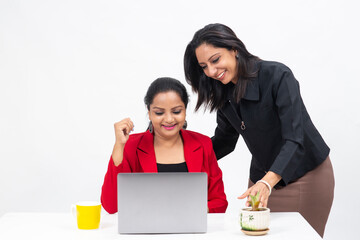 Two professional Indian women working on computer, work from home, Corporate employees holding video meeting with client,