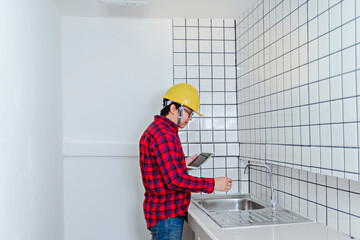 Asian men wear safety equipment holding tablet. Renovating technician during work.