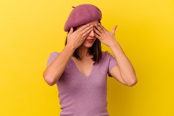 Young caucasian woman isolated on yellow background afraid covering eyes with hands.
