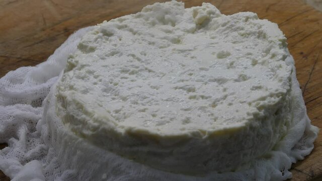 Home made, DIY, fresh feta cheese in cheese cloth on wood